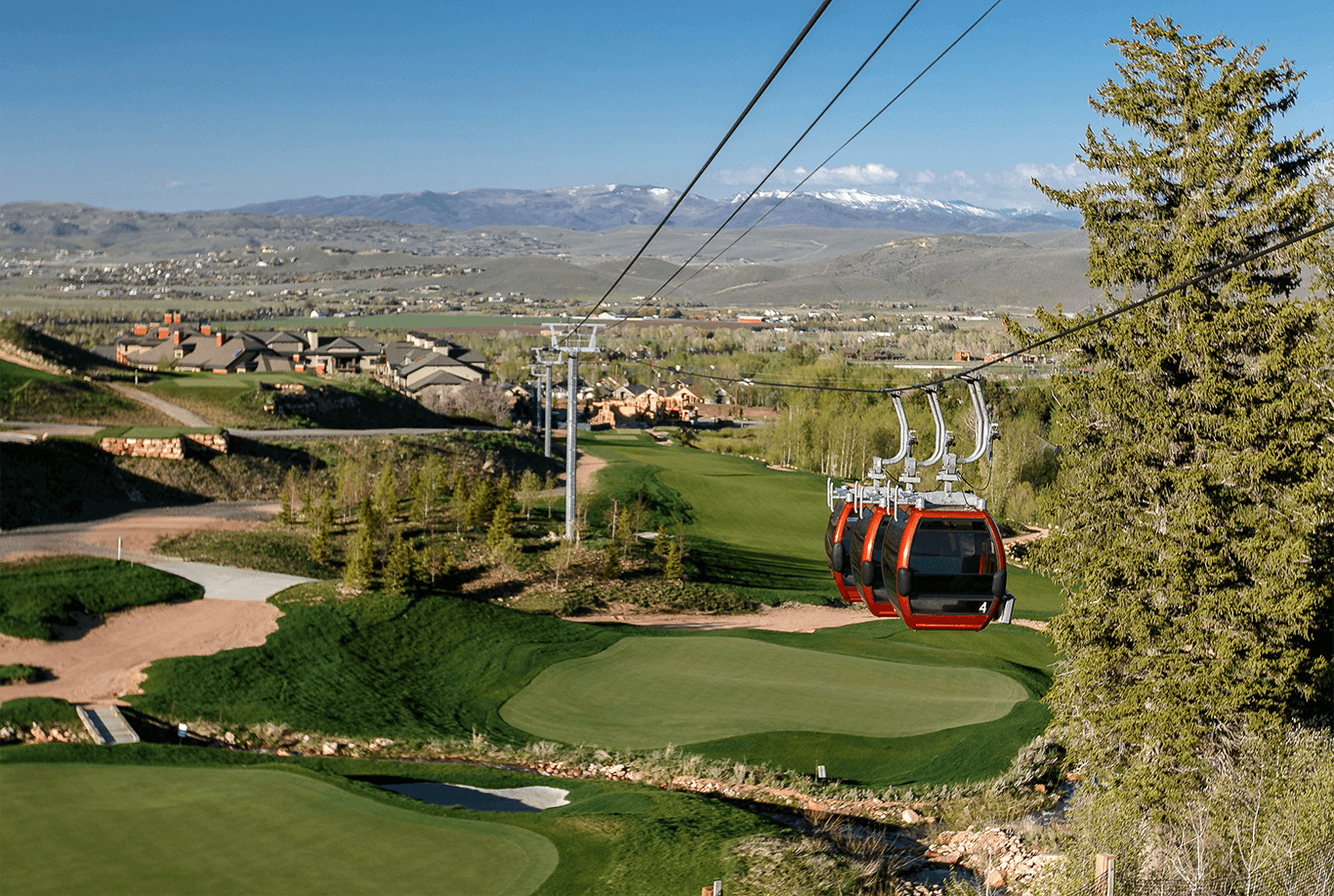 a ski lift going over a green golf course in Canyons, Park City
